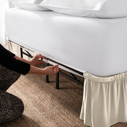 Adjustable bed skirt on a bed showing the elastic strap.