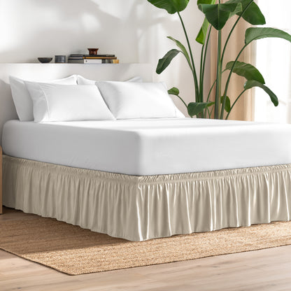 Bed with bed skirt, white bedding, and a plant in a room.