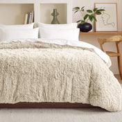 Shaggy duvet on a bed in a bedroom setting with decor elements.