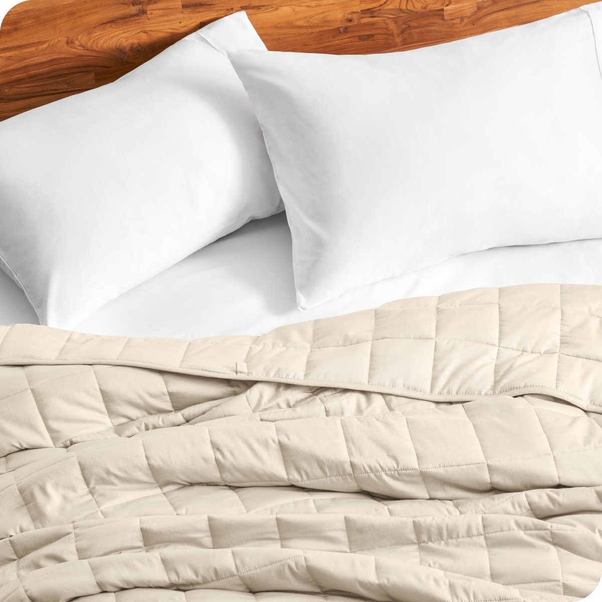Close up of a weighted blanket on a bed next to pillows