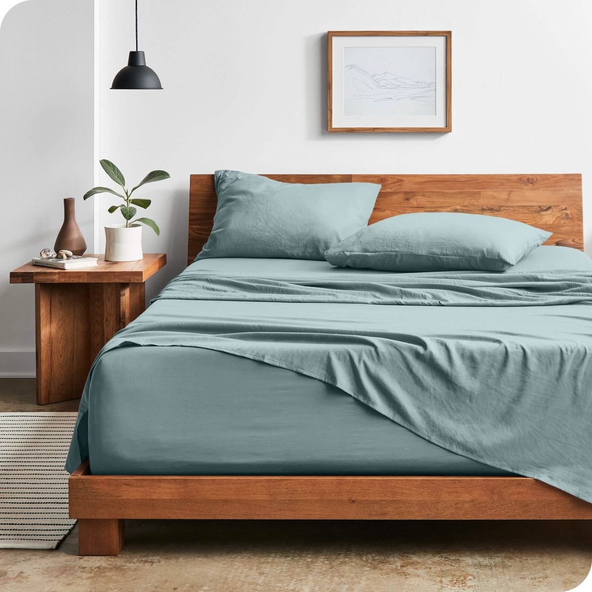 Modern bedroom with washed sheets draped over the end and the side of the bed