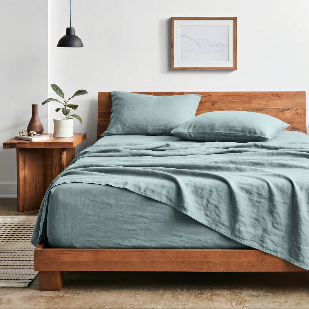 Bedroom with sheet set on a wooden bed frame and side table