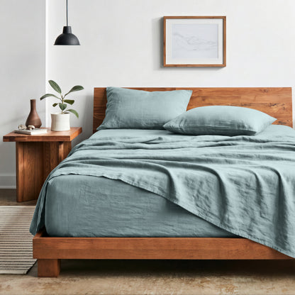 Bedroom with sheet set on a wooden bed frame and side table