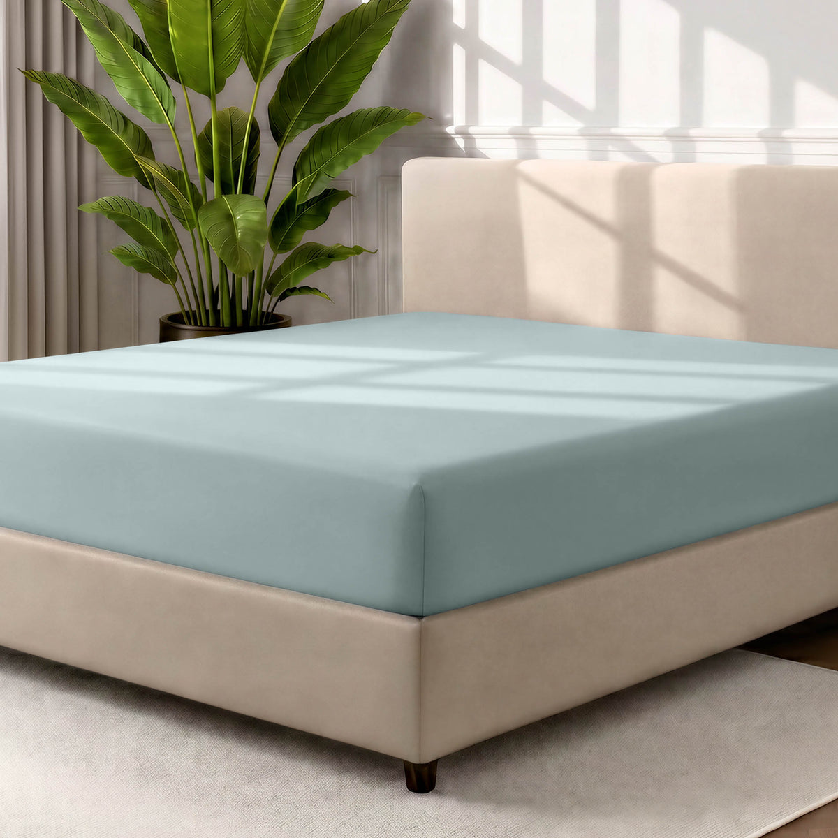 Man adjusting fitted sheet on a bed with white pillows.