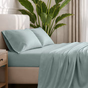 Ultra-soft sheets and pillowcases on a bed with a plant in the background