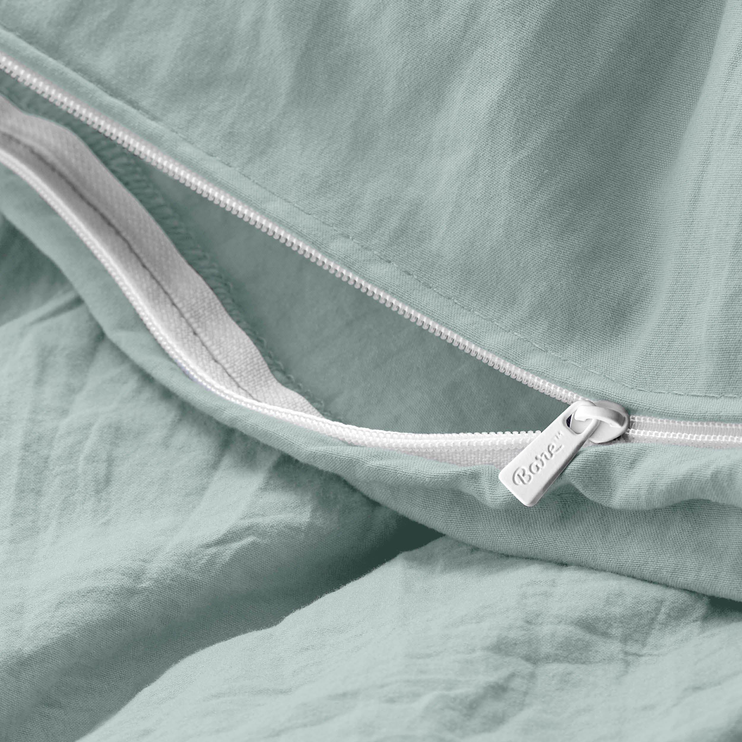 Close-up of a duvet cover with a zipper, featuring the brand Bare Home