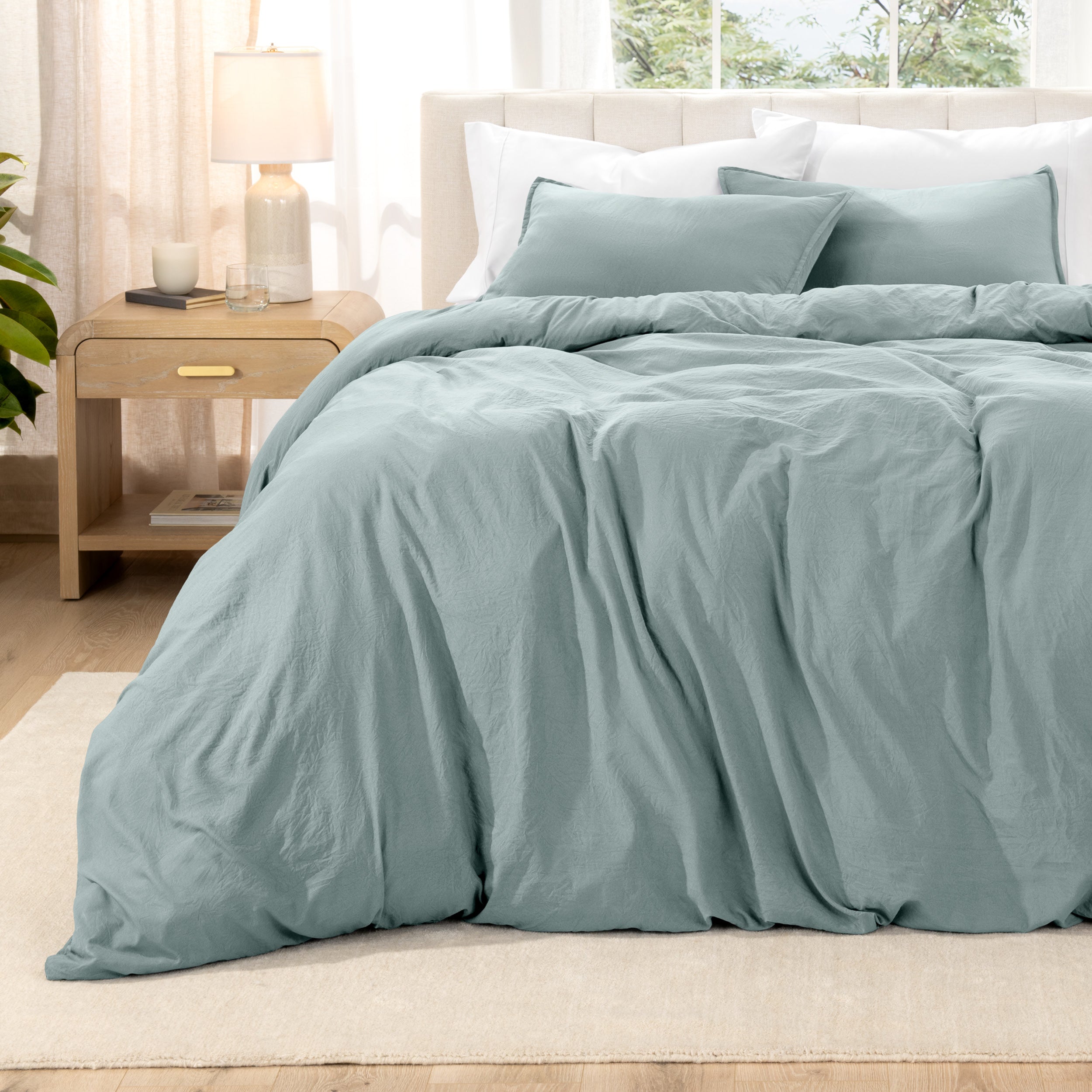 Washed bedding set on a bed with a nightstand in the background