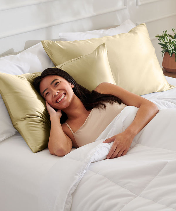 Woman laying on a Champagne silk Pillowcase
