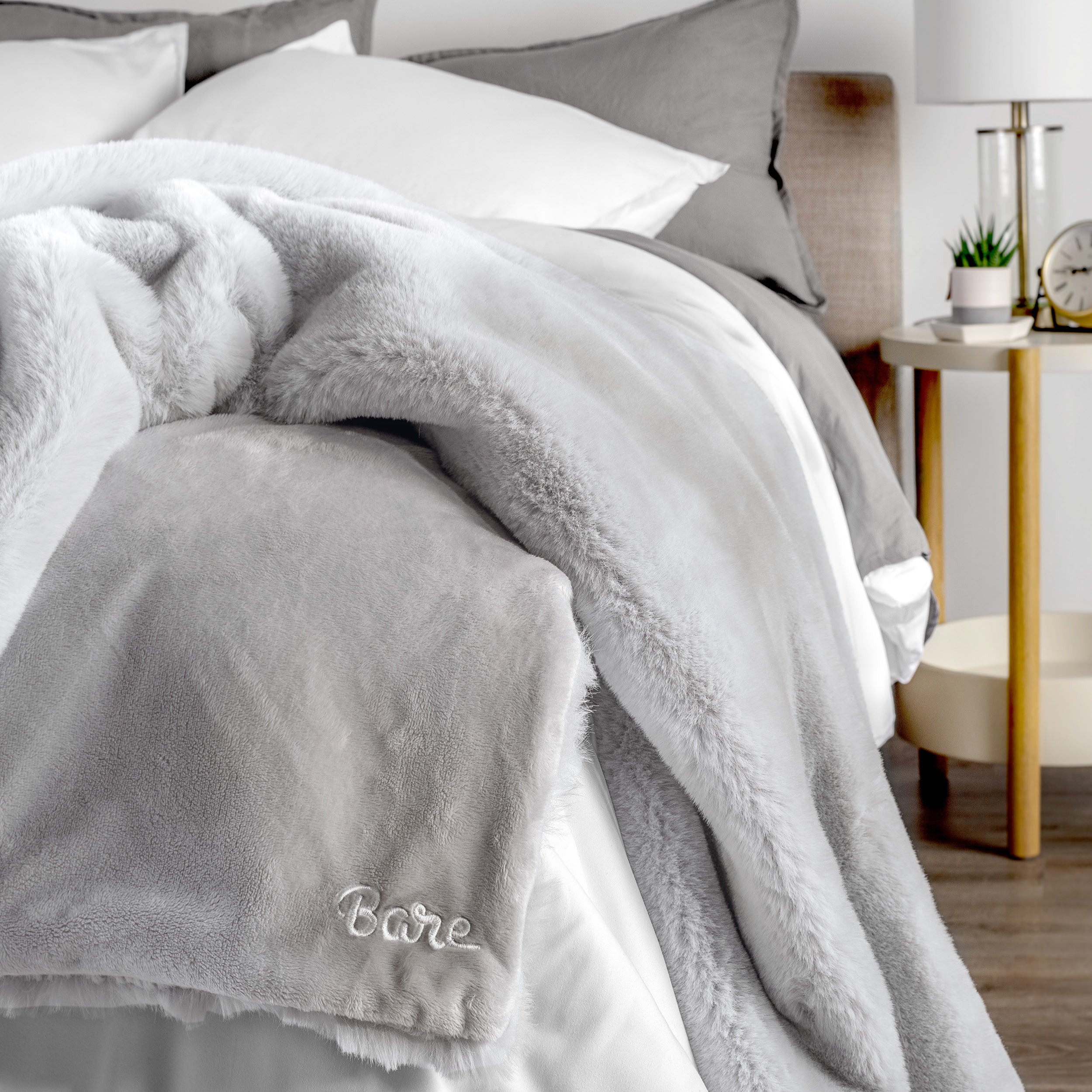 Blanket with 'Bare' branding on a bed in a bedroom setting
