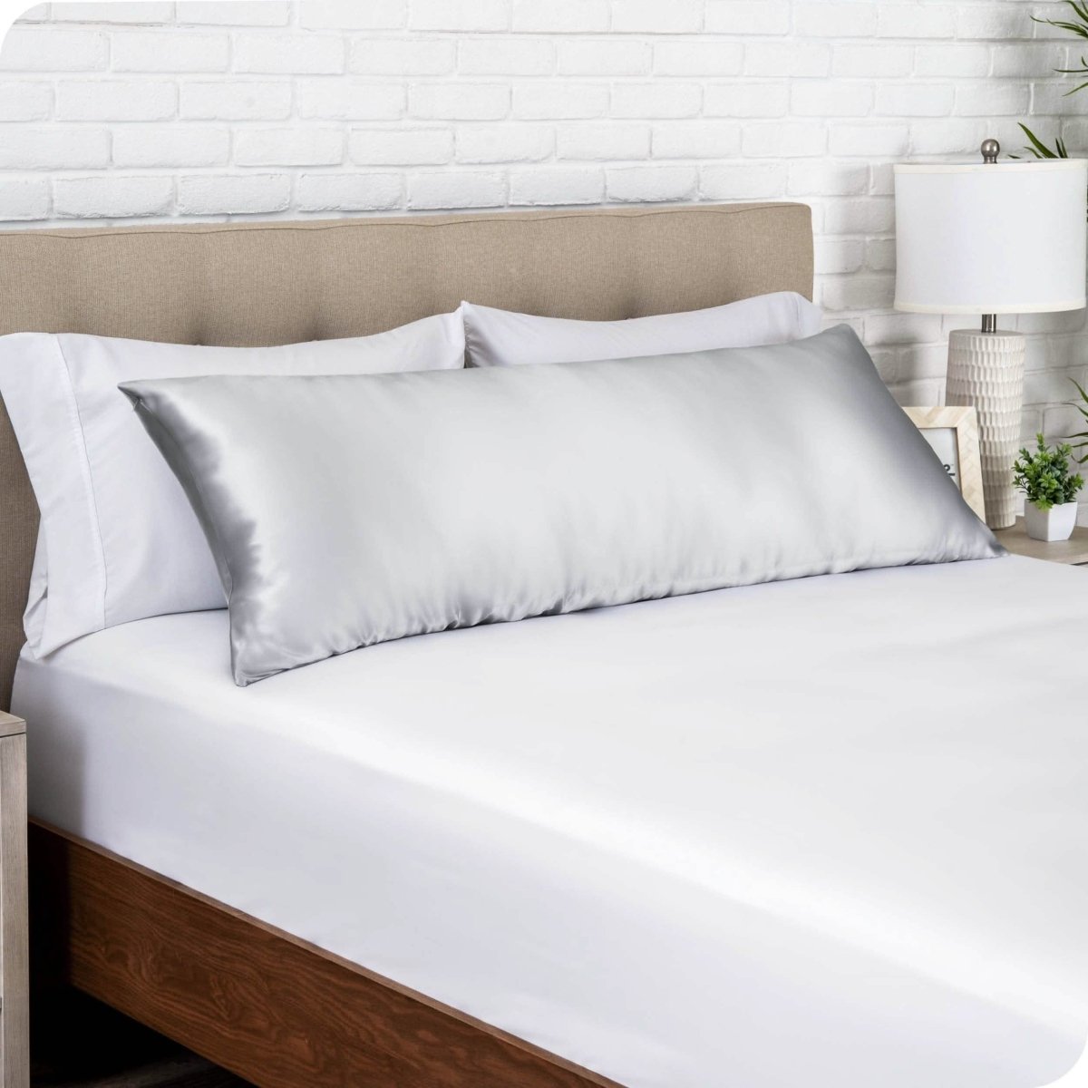 A silk body pillowcase on a pillow resting on a headboard