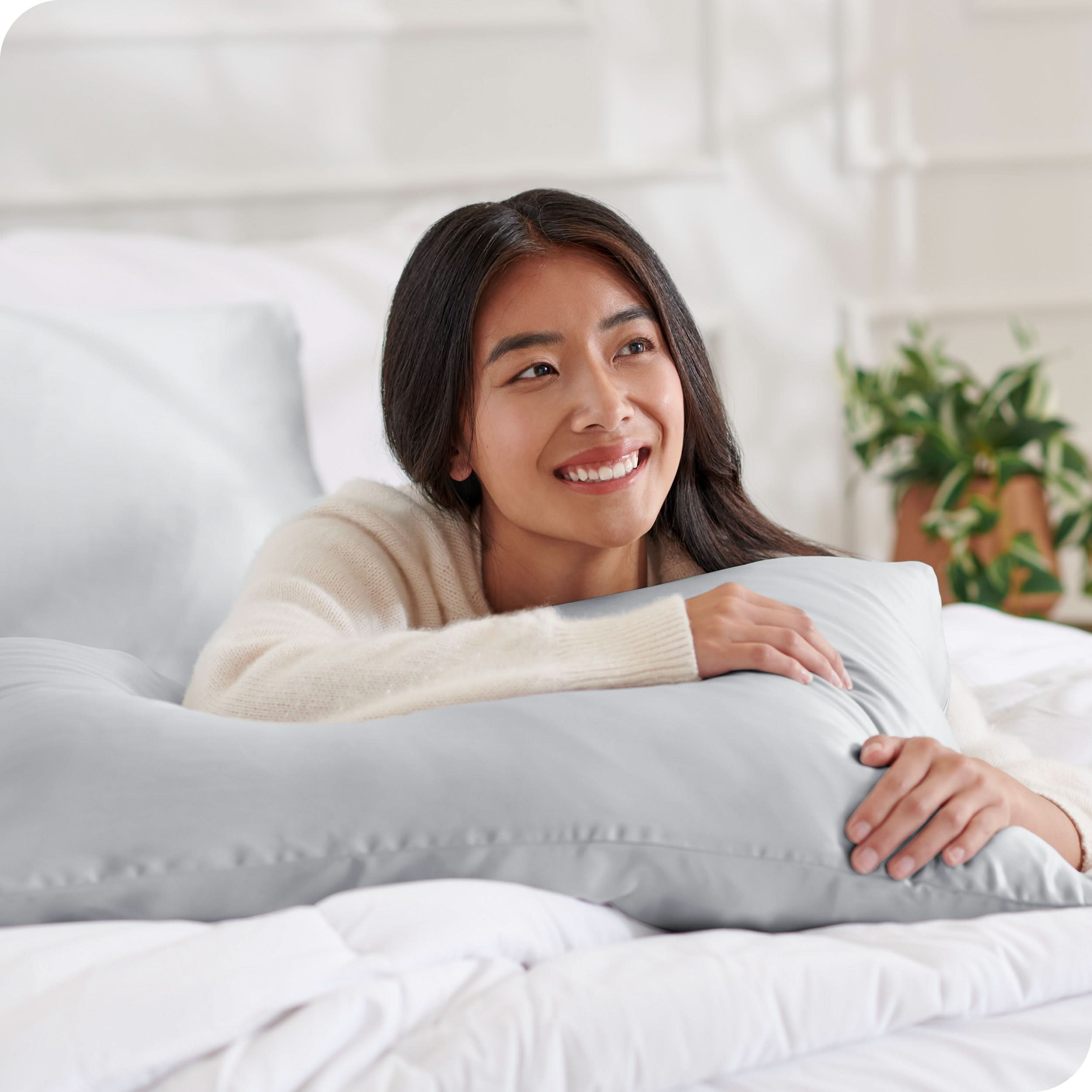 A woman lying on a bed with silk pillowcases