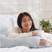Woman lying on a bed with a mulberry silk pillowcase on her pillow