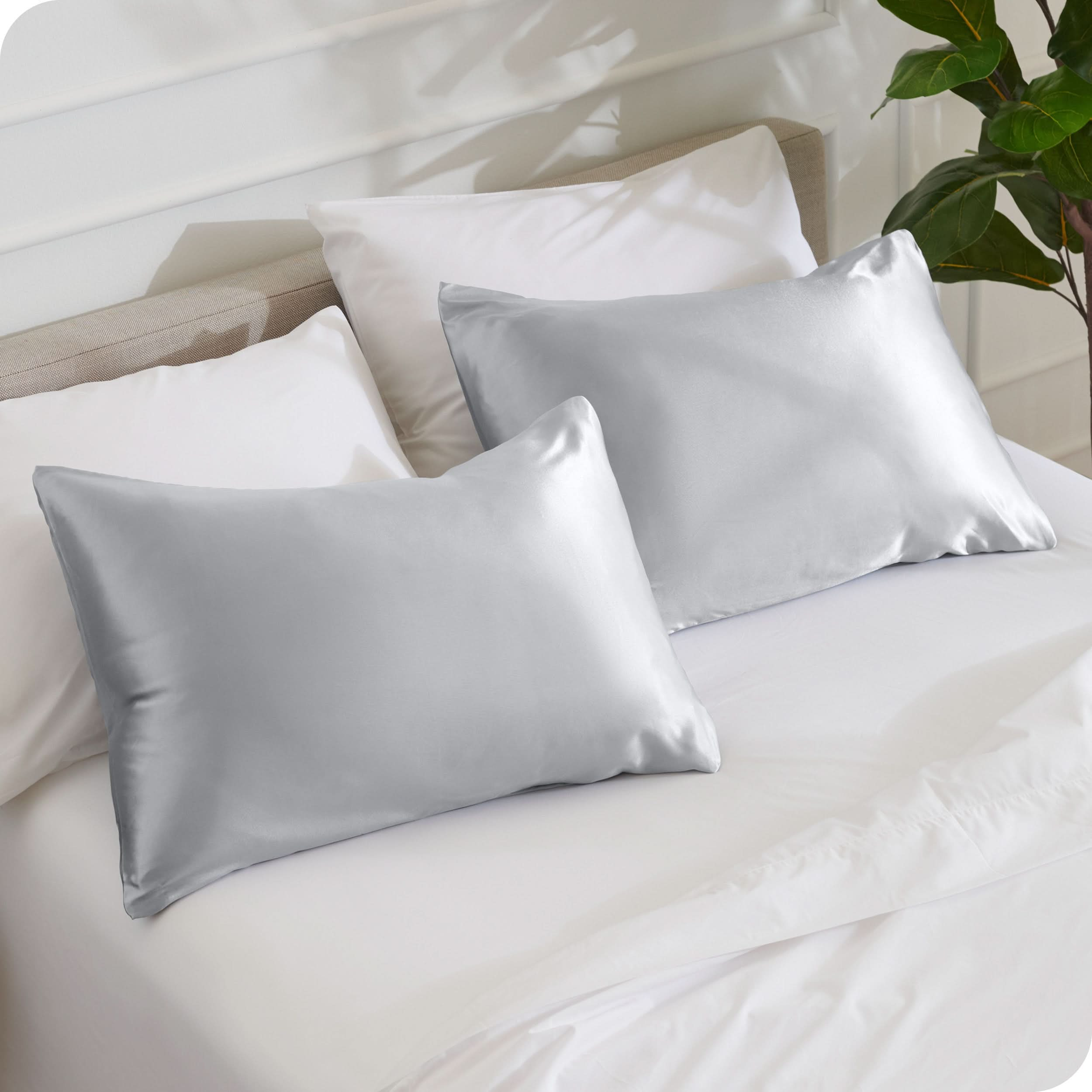 2 silk pillowcases on a bed with white linens