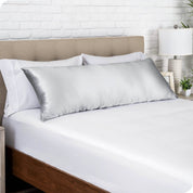 A satin body pillowcase on a bed with white linens