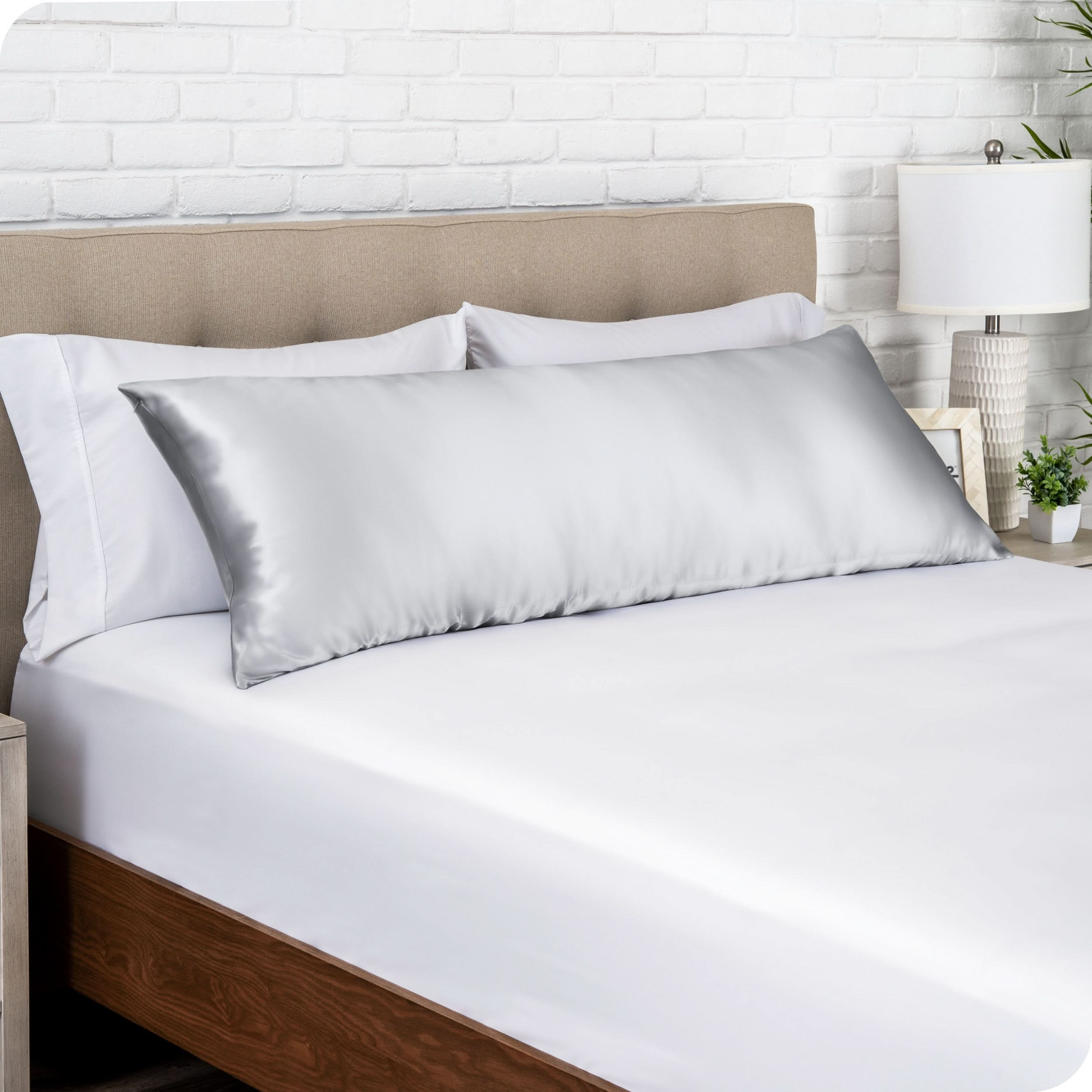 A satin body pillowcase on a bed with white linens