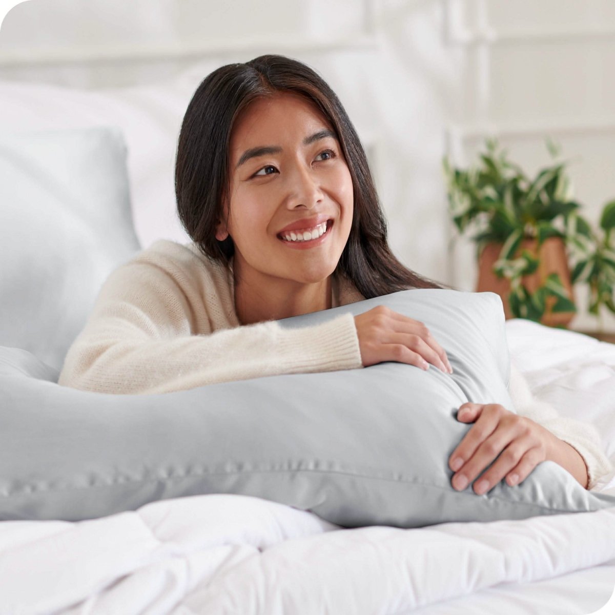 A woman is resting on a satin pillowcase covered pillow