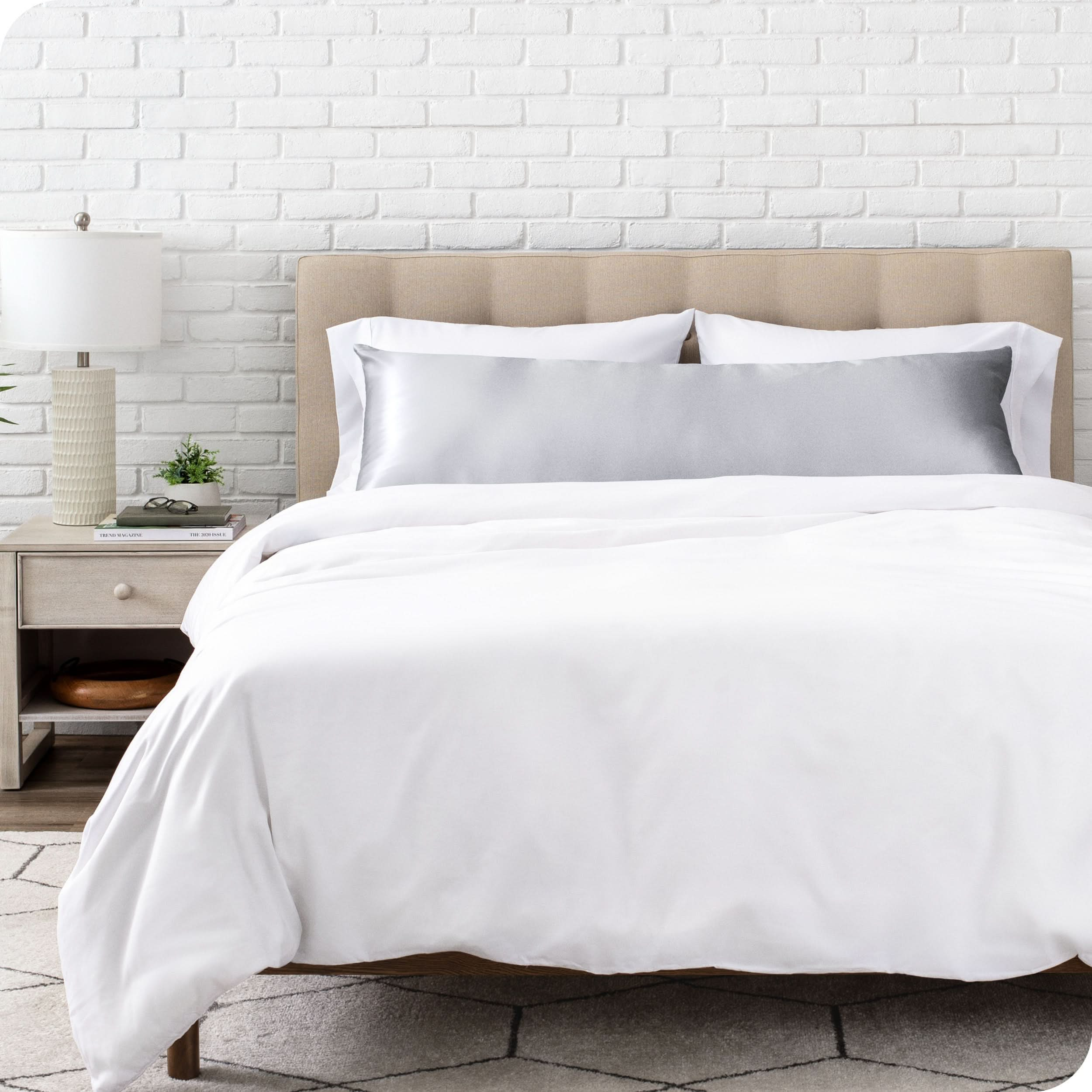 A satin body pillowcase on a bed with white linens