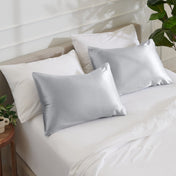 Satin pillowcases on a bed with white bedding