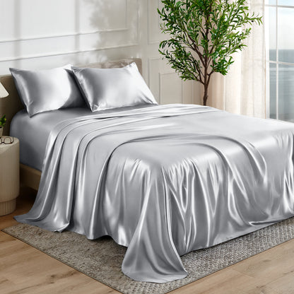 Satin sheet set on a bed in a bedroom with a plant and window in the background.