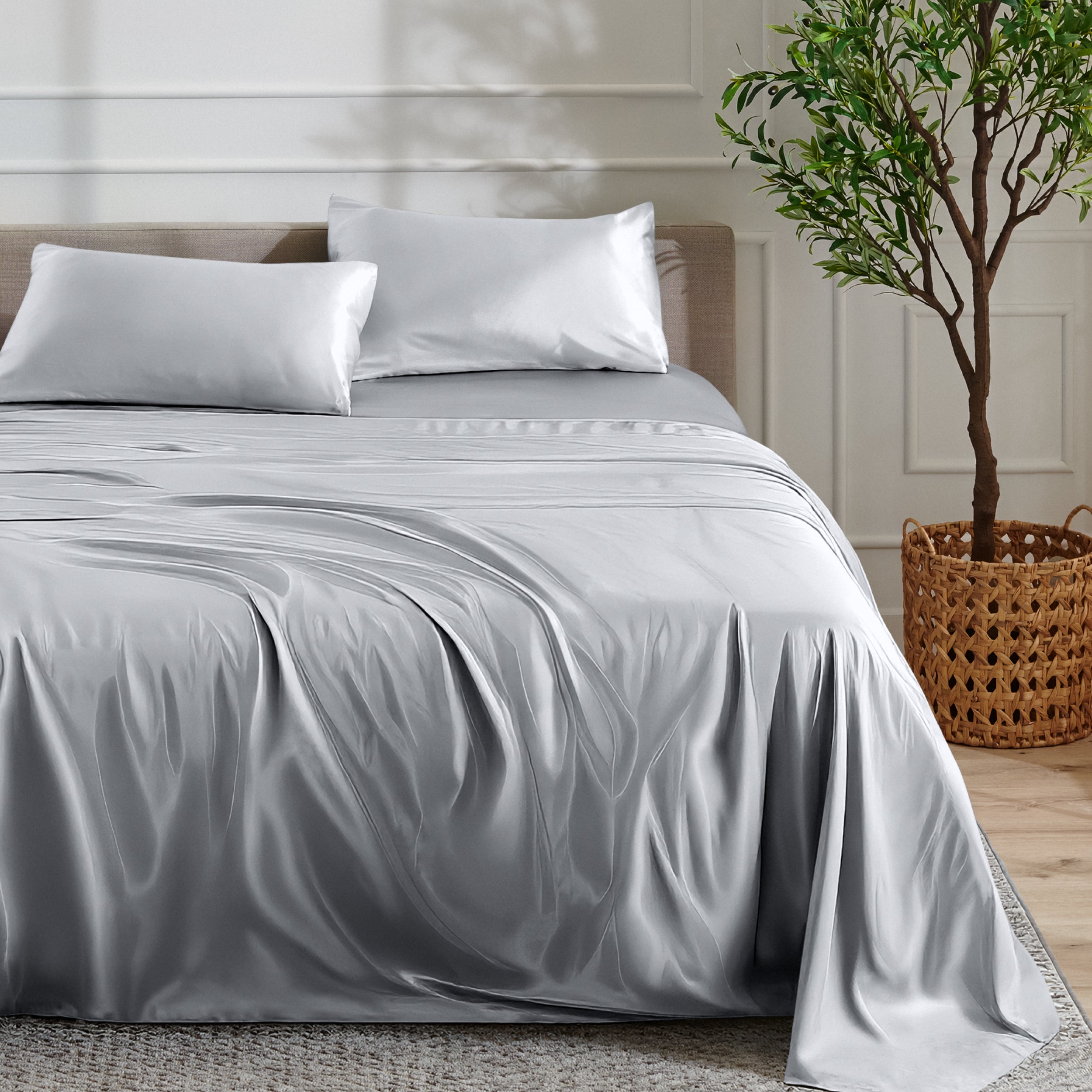 Satin sheet set on a bed with a plant and basket in the background