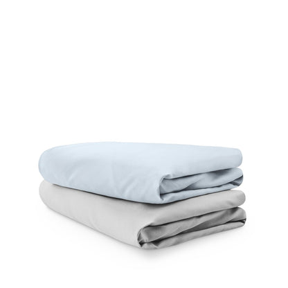 Stack of folded crib sheets on a white background