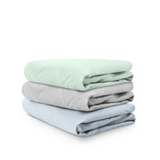 Stack of folded crib sheets on a white background