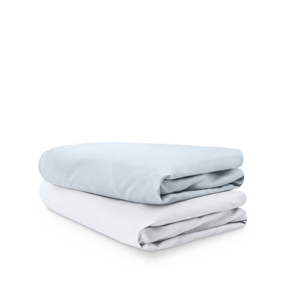 Stack of folded crib sheets on a white background