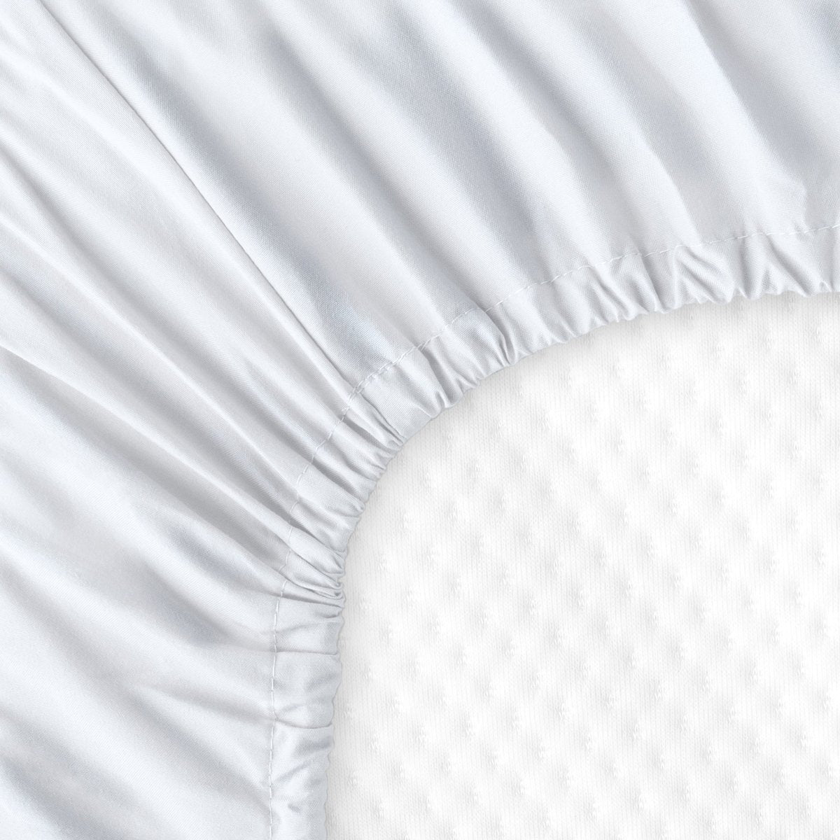 The back of a crib mattress with a fitted sheet on it