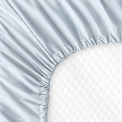 The back of a crib mattress with a fitted sheet on it