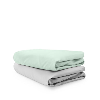Stack of folded crib sheets on a white background