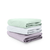 Stack of folded crib sheets on a white background