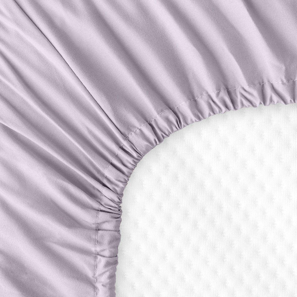 The back of a crib mattress with a fitted sheet on it