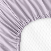 The back of a crib mattress with a fitted sheet on it