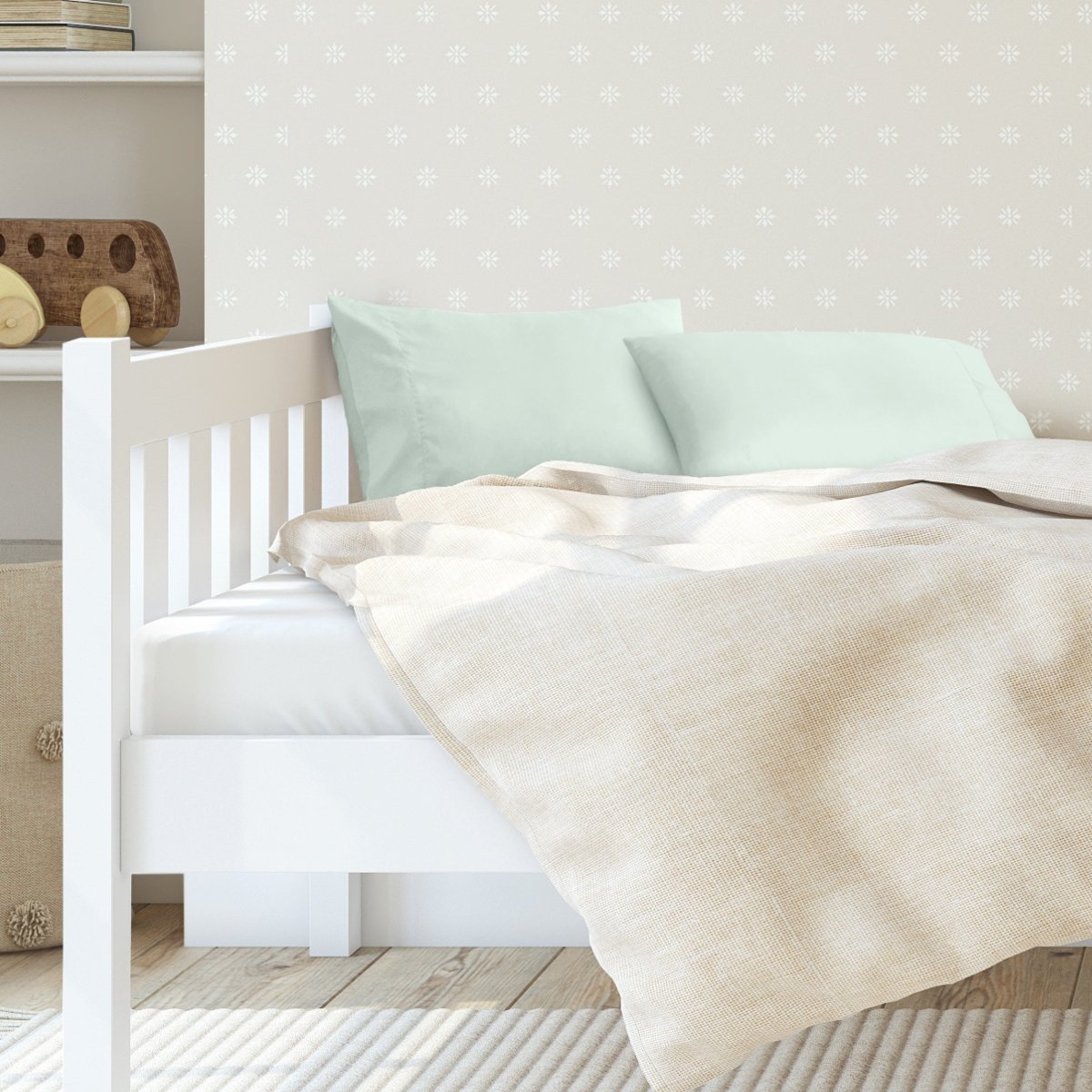 A toddler's bed with 2 microfiber pillowcases on pillows
