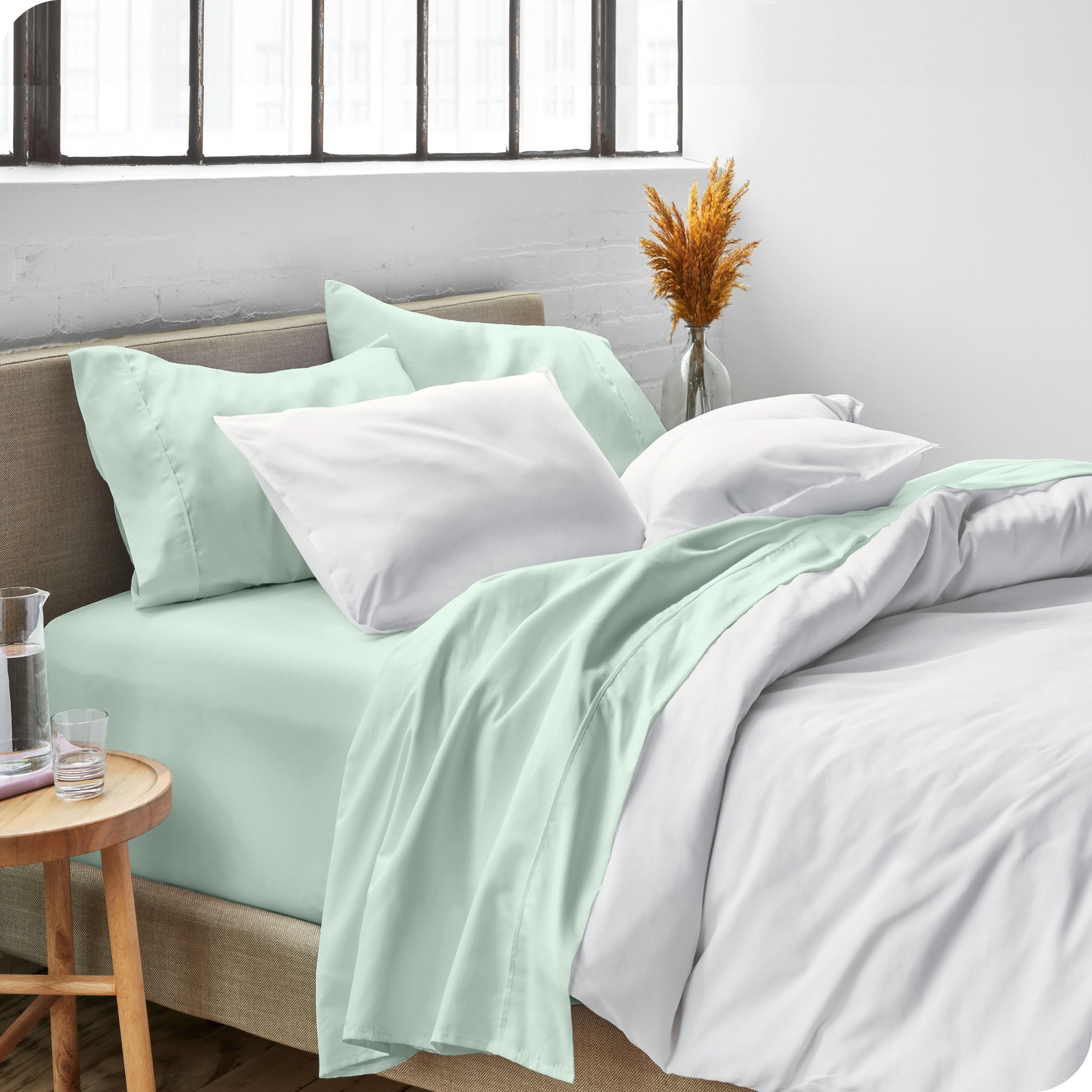 Sheets and a duvet cover on a bed in a bright bedroom