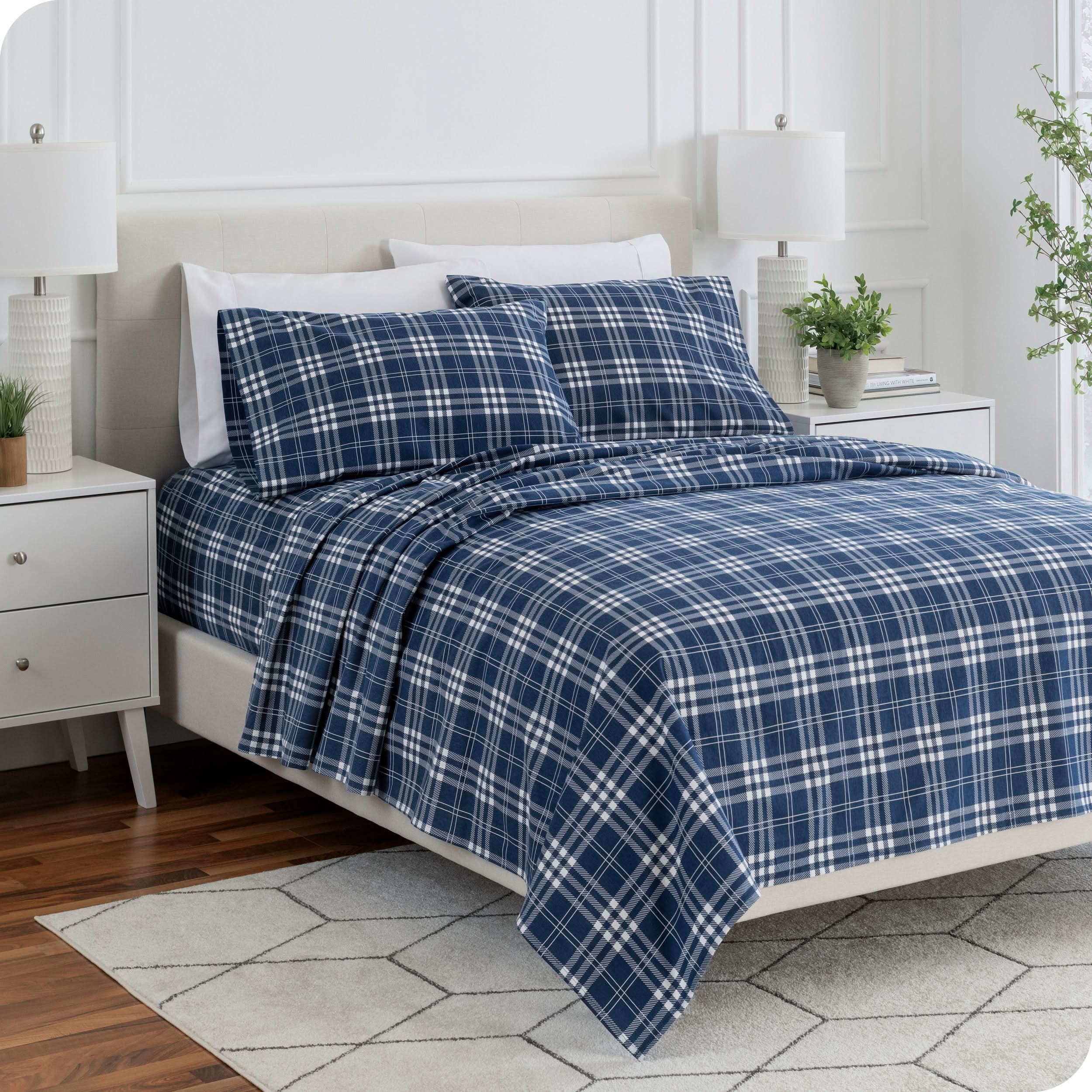 A bed made with printed flannel sheets