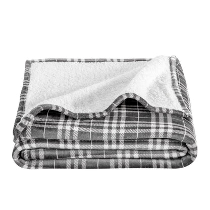 Folded plaid blanket with white lining on a white background
