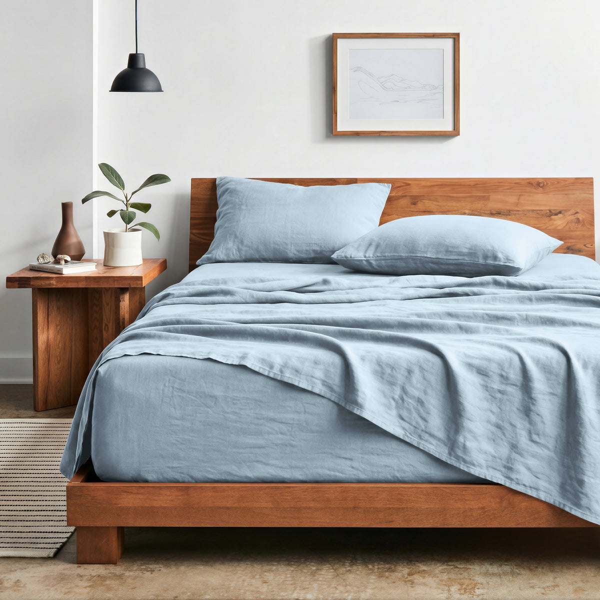 Bedroom with sheet set on a wooden bed frame and side table