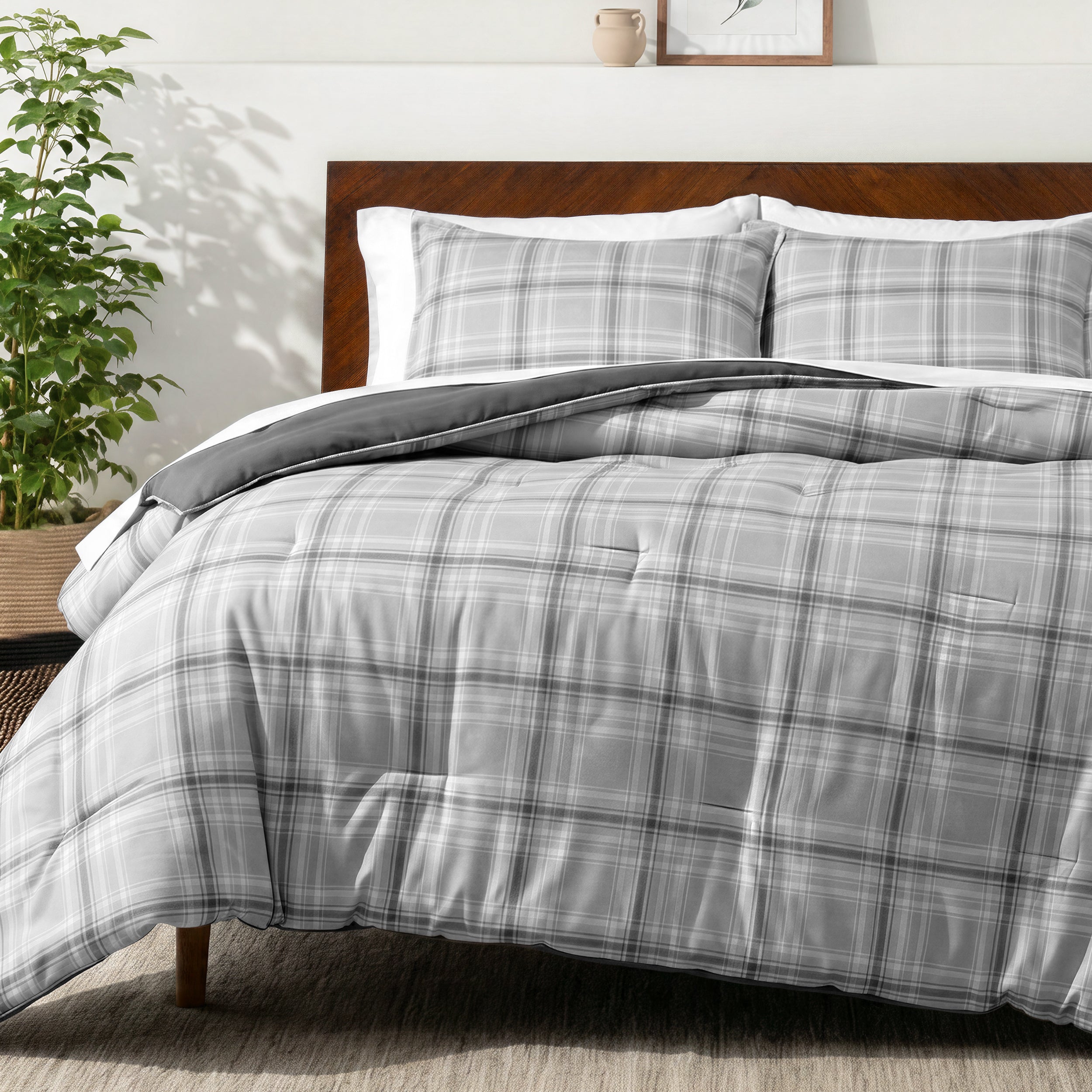 Bedding set on a bed in a bedroom with a side table and lamp.