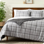 Plaid comforter set on a bed with white sheets