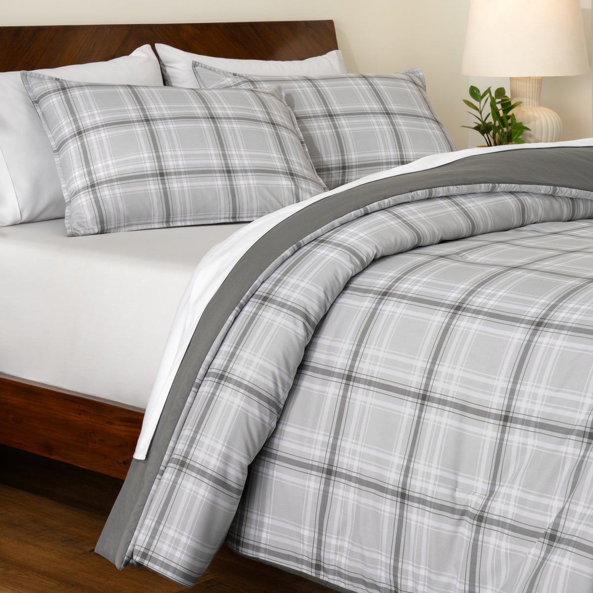 Track stitch comforter on a bed with white pillows and a wooden headboard.