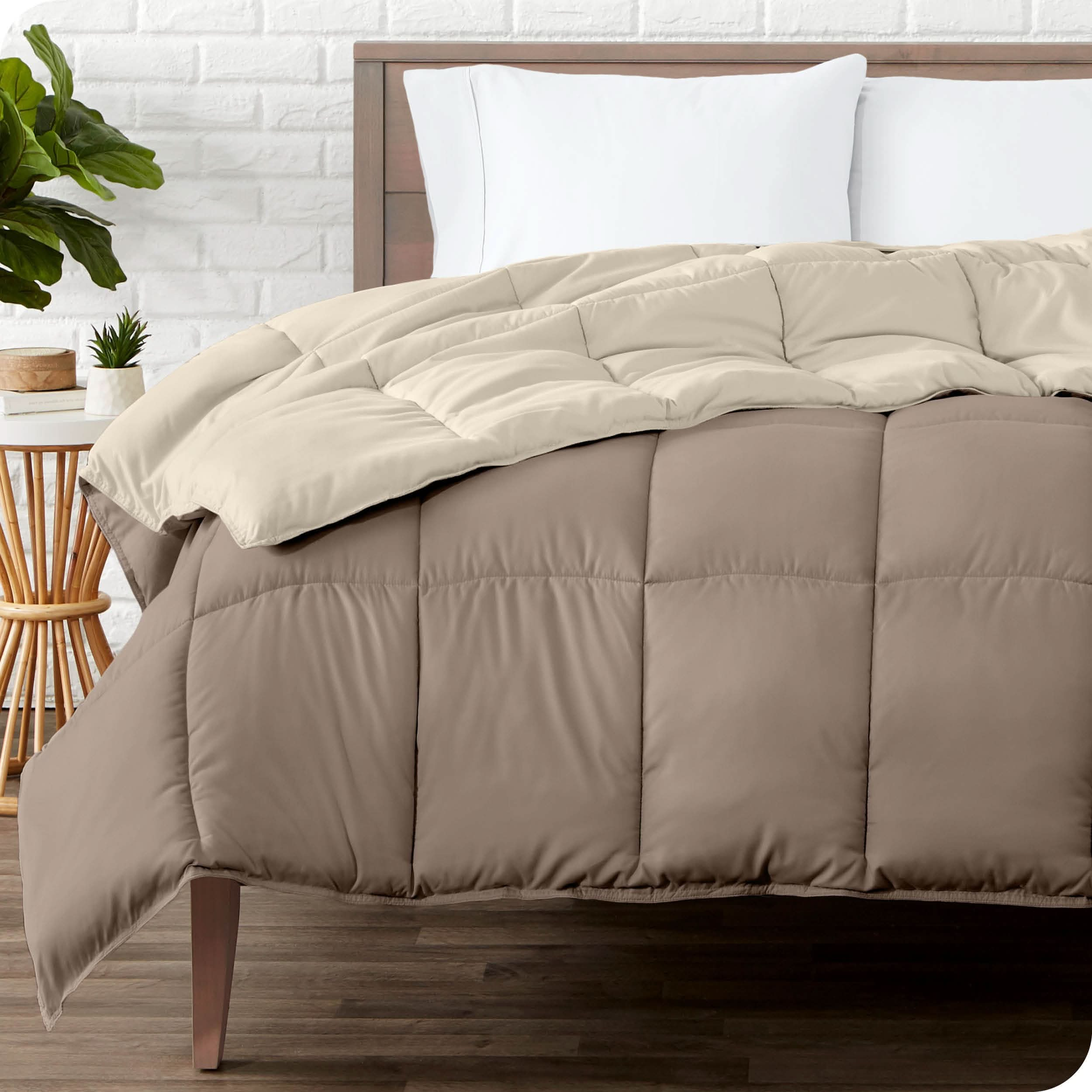 Wooden bed frame with a reversible comforter on the mattress. The comforter is folded back showing the two different colored sides.