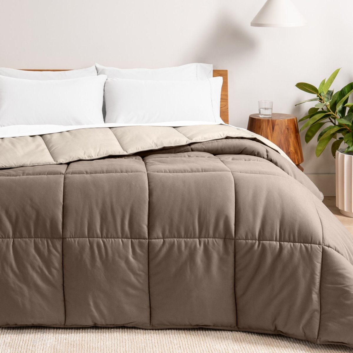 Bed with reversible comforter and white pillows in a bedroom setting