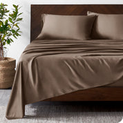 Wooded bed frame with bamboo sheets on the bed