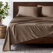 Wooded bed frame with bamboo sheets on the bed