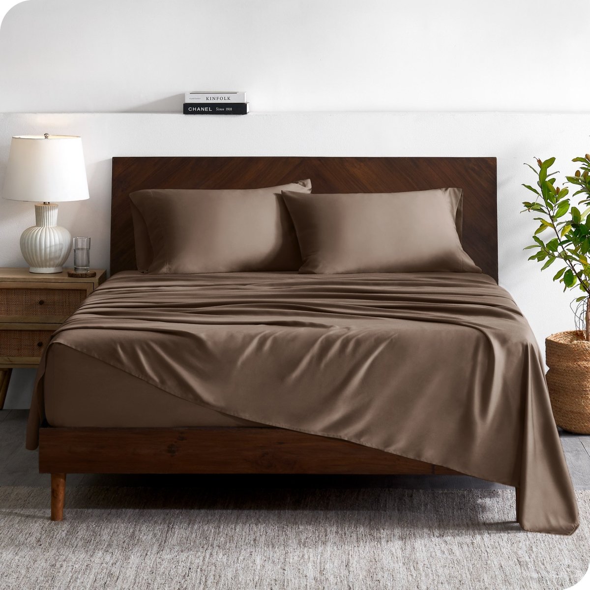 A contemporary bed with a sheet set and a wooden headboard.
