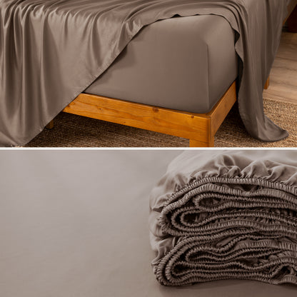 A fitted sheet on a mattress with wooden bed frame and folded on a dark surface