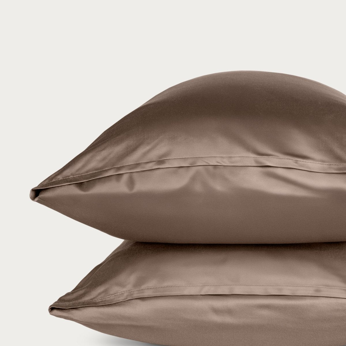 Bamboo pillowcase and bedding against a woven headboard with a plant in the corner.