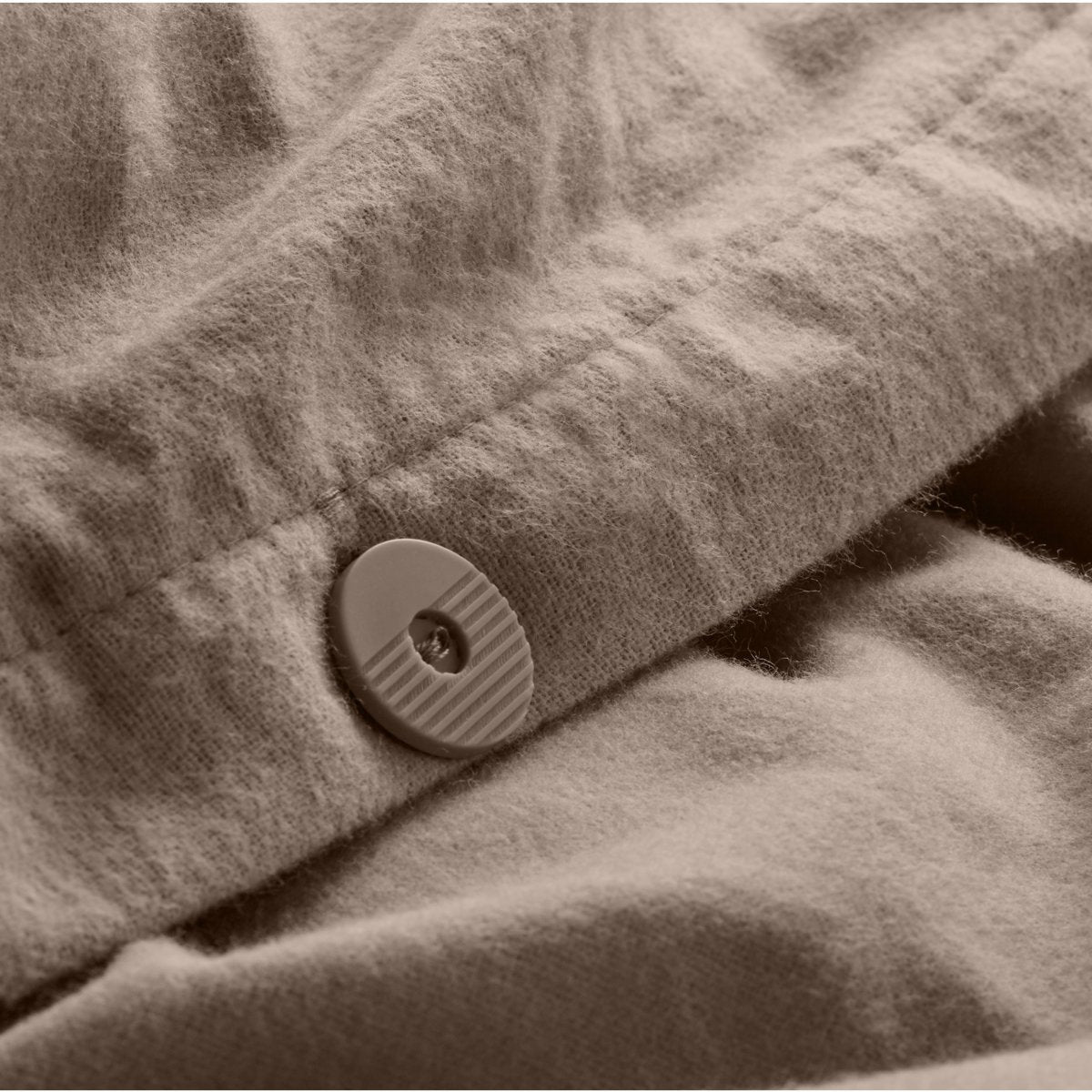 Close up of the button closure on a flannel duvet cover