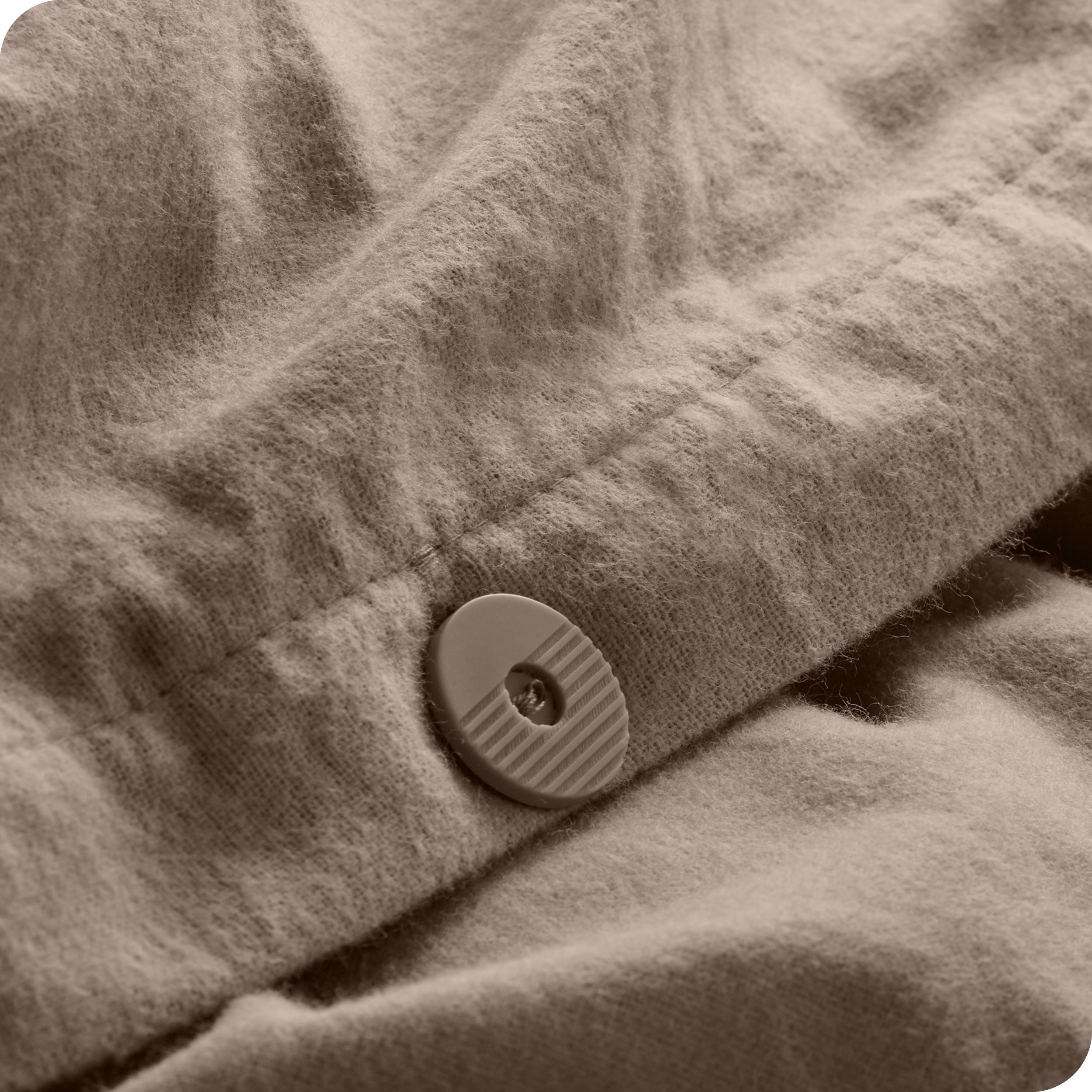 Close up of button for keeping duvet insert inside the flannel duvet cover